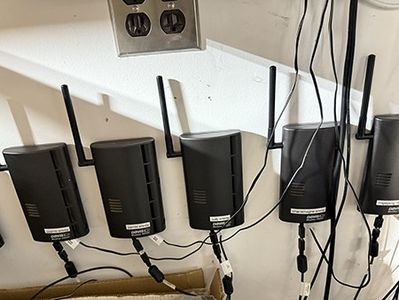 Five Davis Envoy receivers in a row under a shelf, antennas raised, USB cables running down.