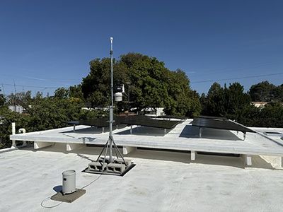 The station mast back on the new white foam roof, the solar array running away behind it.